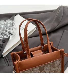 Detail of comfortable dual handles and C-pattern canvas on brown PU leather tote bag