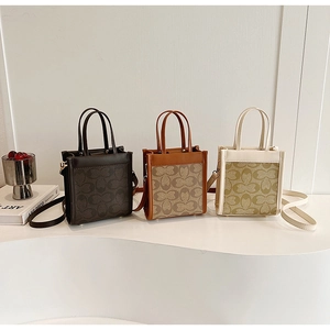 Detailed view of three checkered mini tote bags in black, tan, and beige on a display