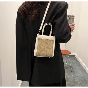 Mirror selfie showing the scale of a beige monogram tote bag with brown leather handles