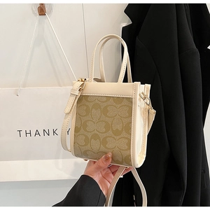 Detail of a mini plaid crossbody bag with cream handles and adjustable shoulder strap