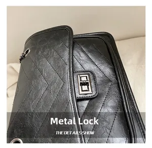 Détail du cuir matelassé noir avec fermoir rotatif en métal gris anthracite brillant