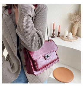 Détail du sac en cuir matelassé bordeaux avec coutures en V et bandoulière en chaîne