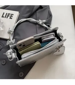 Interior view of silver bow shoulder bag showing spacious storage for phone and wallet