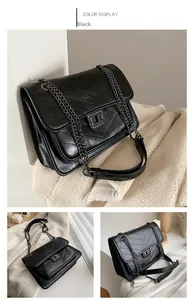 Détail du sac bandoulière noir avec matelassage en V et fermoir tournant en métal doré