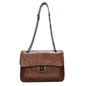 Sac bandoulière rétro marron avec matelassage en V et bandoulière chaîne sur fond blanc