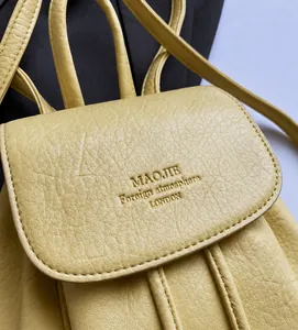 Detailed close-up of light yellow PU leather backpack featuring distinct lychee texture