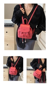 Detail view of red mini leather backpack with drawstring closure and metal ball charms