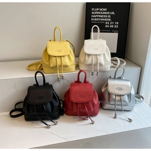 Group display of five colorful mini leather backpacks with flap and drawstring closure