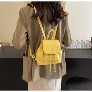 Detail of yellow mini PU leather backpack with lychee texture and drawstring closure