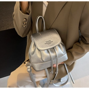 Detail of silver metallic mini backpack with lychee texture and drawstring closure