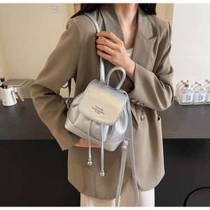 Silver metallic leather mini backpack with drawstring and sphere charms in lifestyle view