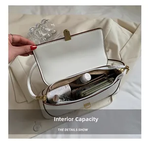 Close-up showing the spacious interior and compartments of the vintage white shoulder bag