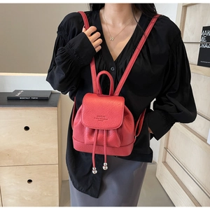 Detailed view of red mini leather backpack with drawstring closure and magnetic flap