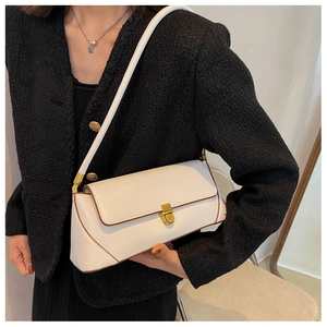 Close-up of white leather baguette bag with brown edges and golden square buckle