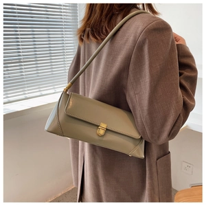Detail of sage green faux leather baguette bag featuring a rectangular gold metal buckle