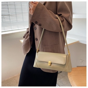 Detail of light green baguette bag featuring glossy finish and gold metal buckle