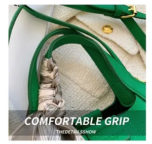 Detail of dark green lychee grain leather bucket bag with silk scarf wrapped handle