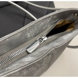 Detail of silver metallic cloud bag featuring premium zipper and reinforced stitching
