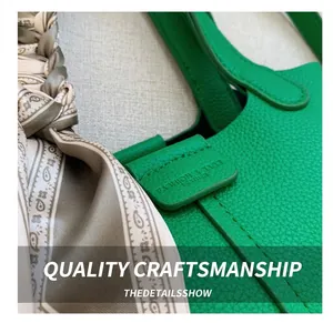 Detail of green litchi grain leather bucket bag with decorative scarf and logo engraving