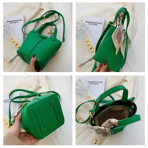 Detail view of bright green lychee grain bucket bag with decorative silk scarf and strap