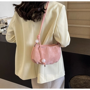 Pink soft PU cloud bag detail with shoulder strap and white bead charm on a model