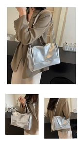 Detail view of silver metallic leather tote bag with silver metal bow and chain strap
