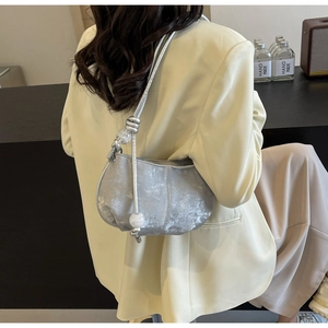 Detail of silver grey cloud bag with cracked texture and decorative beads on shoulder strap