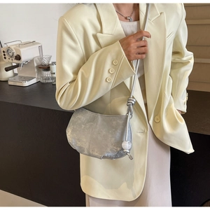 Detail of silver metallic cloud bag with chunky chain strap and knotted sphere accent