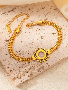 Vue détaillée du pendentif soleil doré sur le bracelet gourmette en acier inoxydable