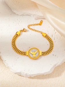 Vue détaillée du bracelet doré avec relief d'oiseau sur fond de nacre blanche