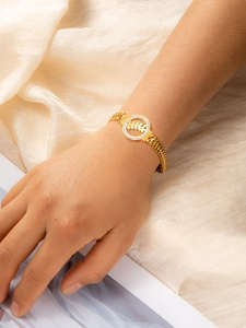 Détail du bracelet doré à double chaîne avec pendentif feuille et diamants blancs fins