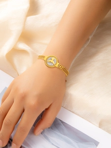 Détail du bracelet doré avec maille épi de blé et relief d'oiseau sur insert en nacre