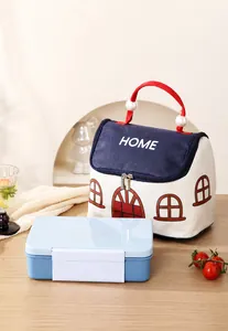 Detail van geïsoleerde lunchtas in huisvorm met parelhandvat en blauwe lunchbox