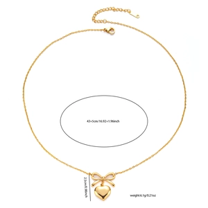 Elegant gold bow necklace with polished heart pendant and tassel details on white background