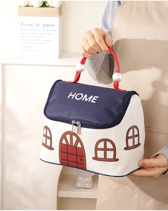 Detail van de geïsoleerde tas in huisvorm met rode parelgrepen en tekst HOME