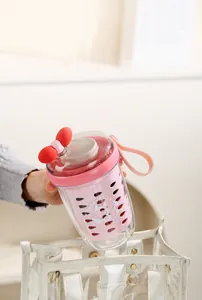 Détail d'un gobelet à salade rose double couche avec motif écureuil dans un sac cabas