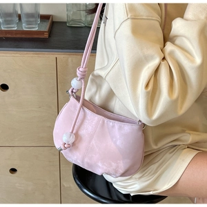 Detail of pink half-moon shoulder bag with marble beads and knotted strap on model