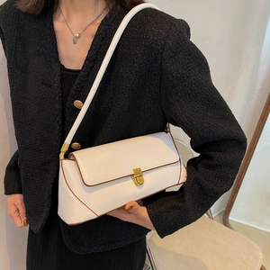 Retro white baguette shoulder bag with gold clasp and brown piping on black tweed coat