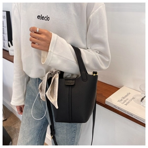 Detail of black lychee grain leather bucket bag with silk scarf and silver ring