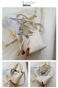 Detail of off-white bucket bag with lychee texture and floral silk scarf on handle