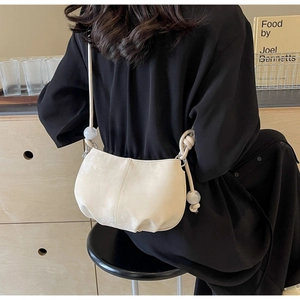 Detail of cream soft PU crossbody bag with large decorative beads and knotted strap