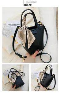 Detail of black lychee grain bucket bag with a decorative floral silk scarf handle