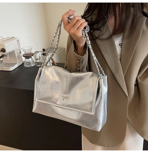 Detailed close-up of silver tote bag featuring retro cracked texture and bow detail