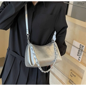 Vue détaillée du sac à bandoulière argenté avec texture froissée et chaîne en métal