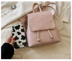 Mini mochila rosa de cuero sintético con cierre de cordón y diseño de solapa