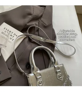 Détail du sac à main argenté avec poignée en perles et bandoulière réglable accessoire