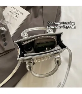 Vue intérieure du sac à main argenté montrant la grande capacité et la poche zippée interne