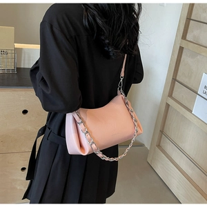 Détail du sac sous l'aisselle en cuir rose texturé avec chaîne argentée épaisse