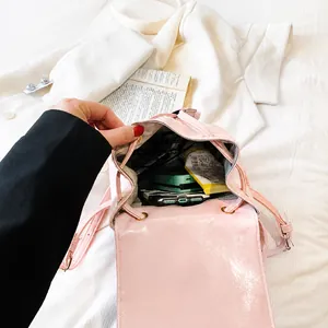 Detalle de la capacidad interna de la mochila rosa brillante con objetos cotidianos