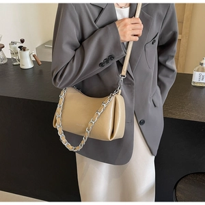 Vue détaillée du sac demi-lune kaki avec chaîne argentée porté par un mannequin